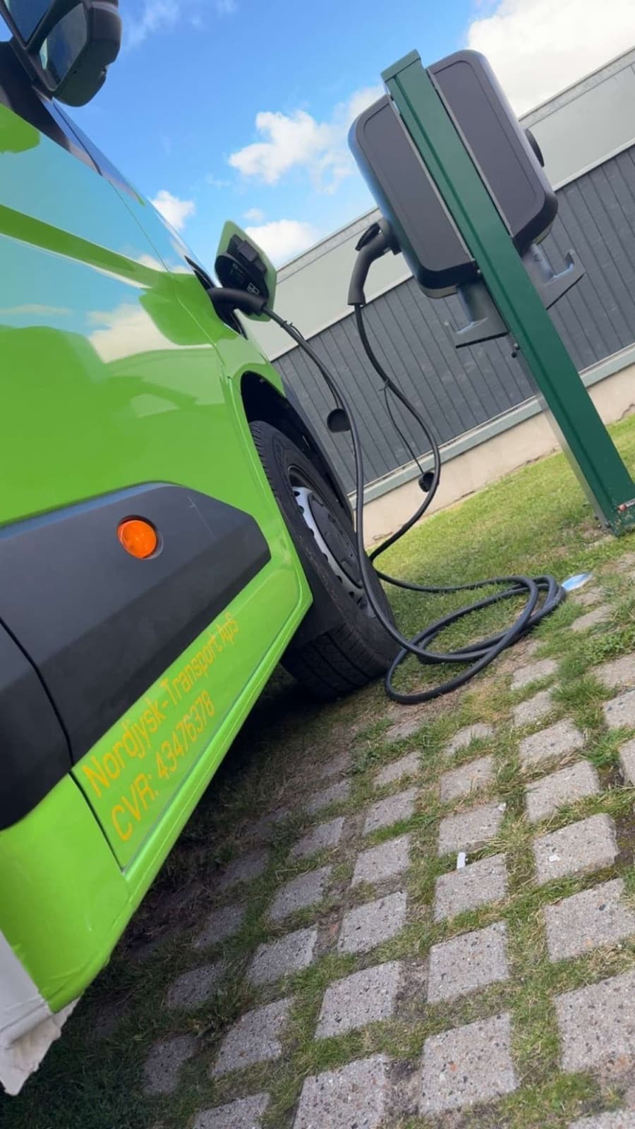 Nordjysk Transports grønne elbil til opladning ved ladestanderen